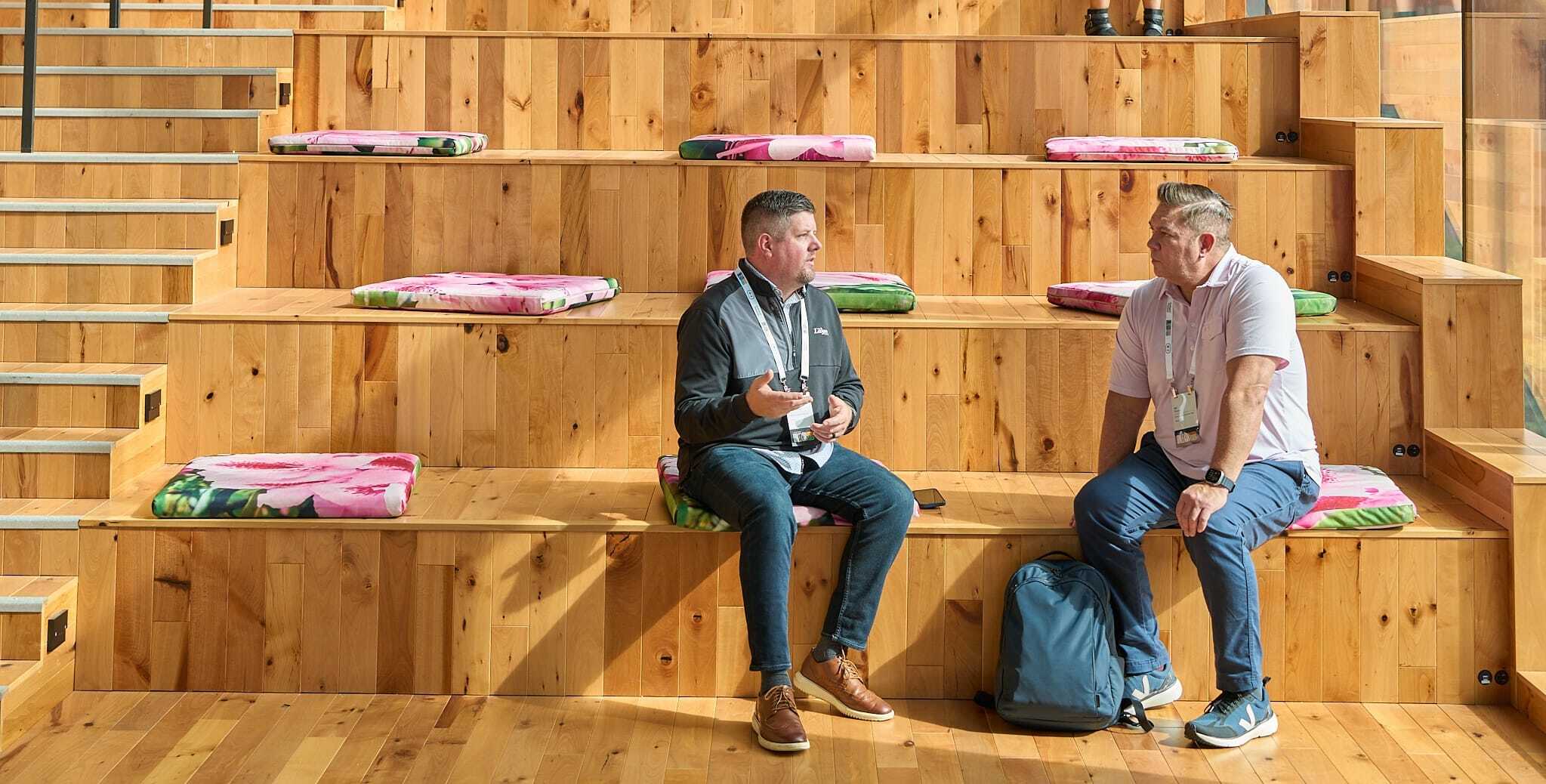 Two men sitting on stairs at work having a conversation